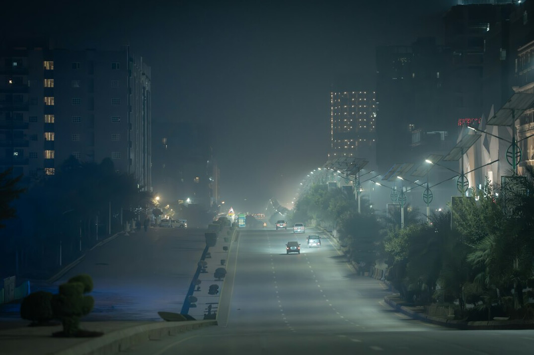 Foggy historic city street at night with dim lighting