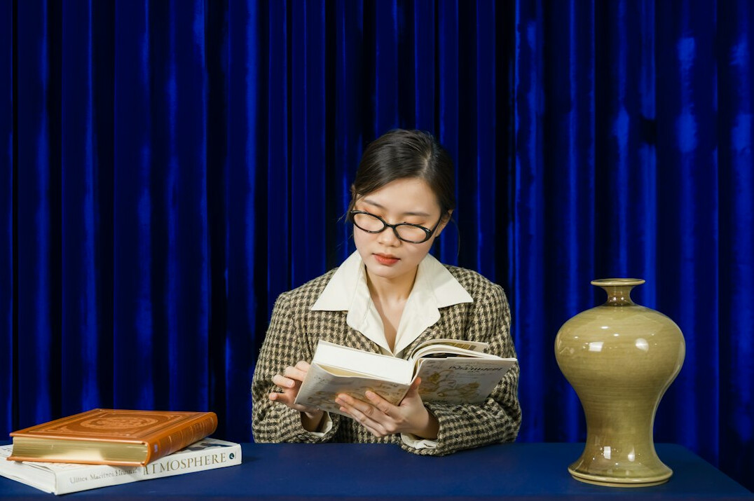 Open book with reading glasses on a wooden table