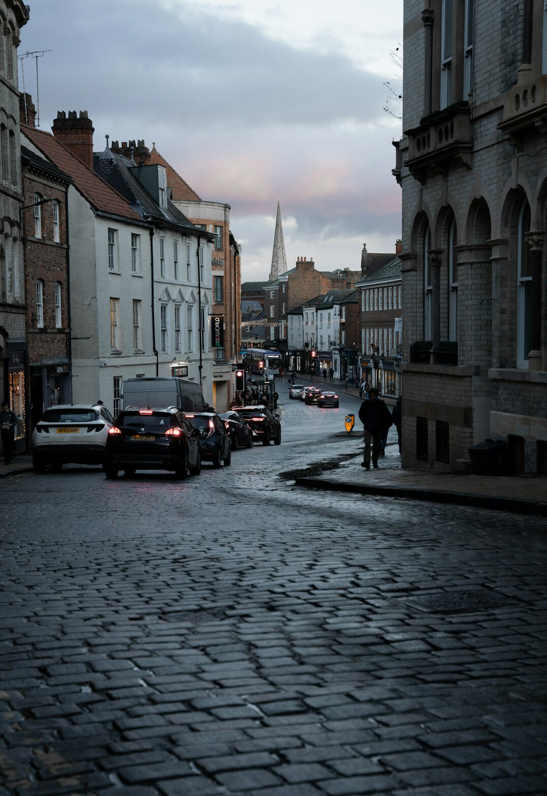 Narrow old cobblestone street at dusk with historic buildings